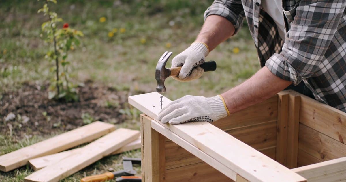 homme construisant un poulailler en bois dans jardin