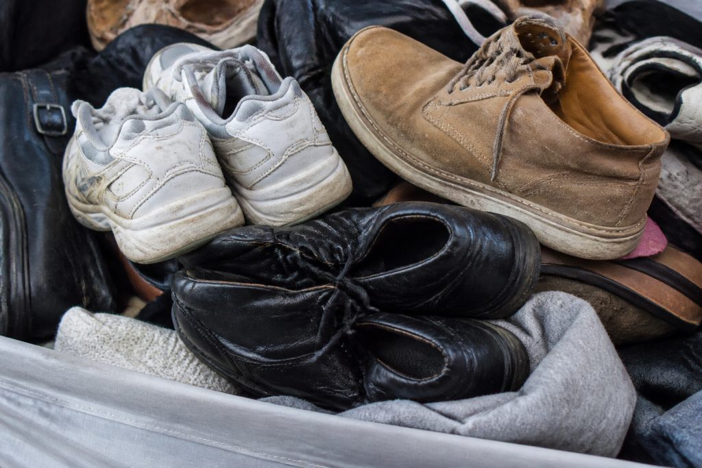 Paires chaussures usees dans un grand bac textile
