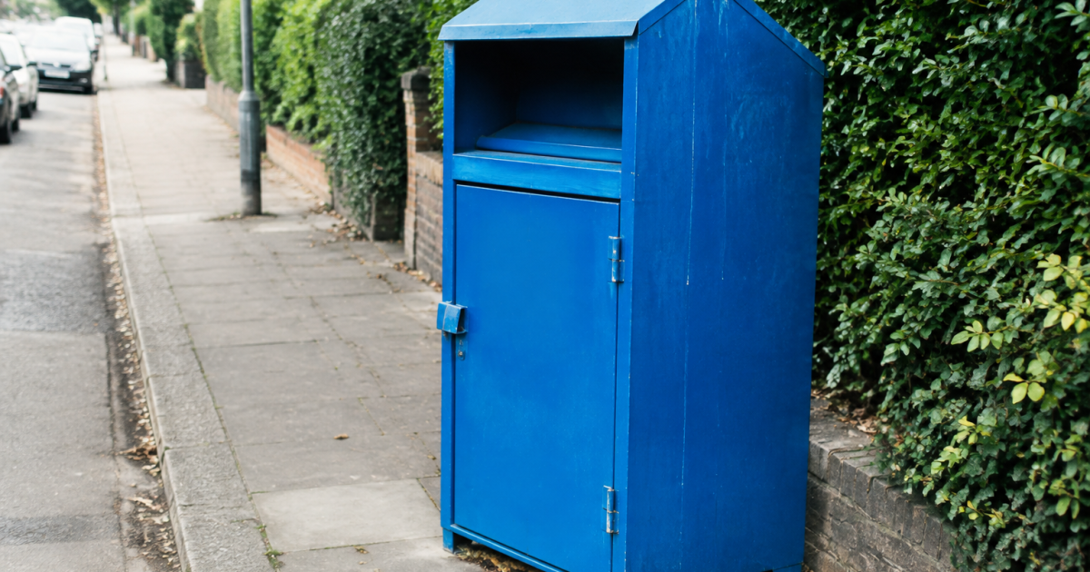 Conteneur bleu de collecte textile debout sur trottoir