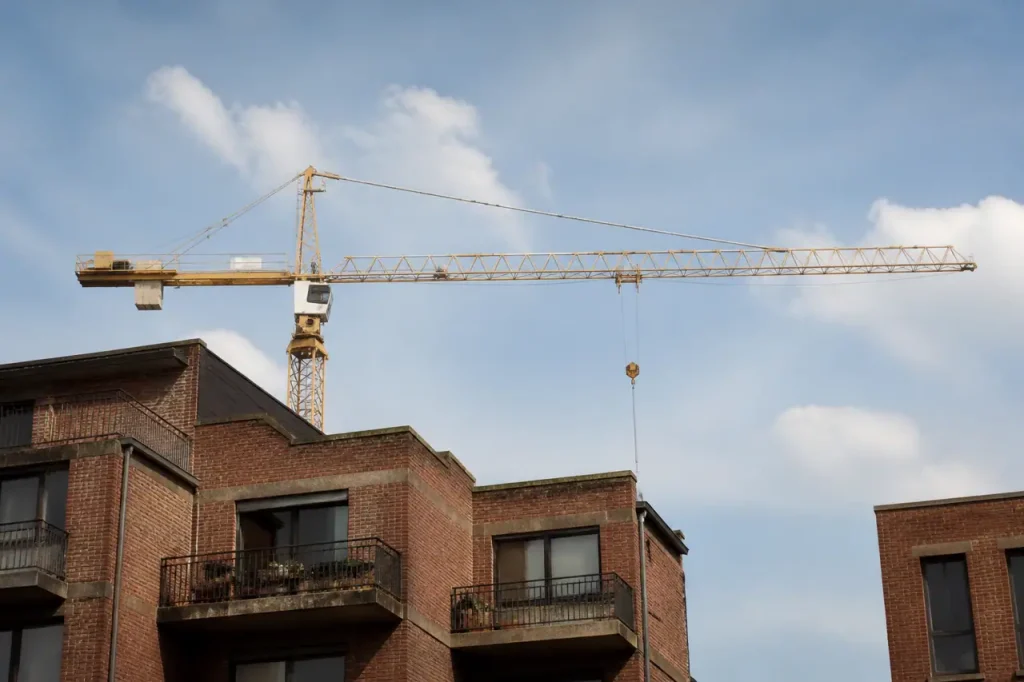 Grues de chantier au-dessus d'immeubles de briques
