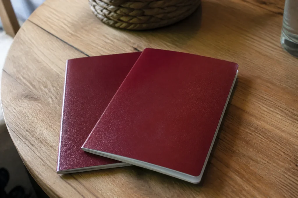 Deux passeports rouges posés sur une table en bois