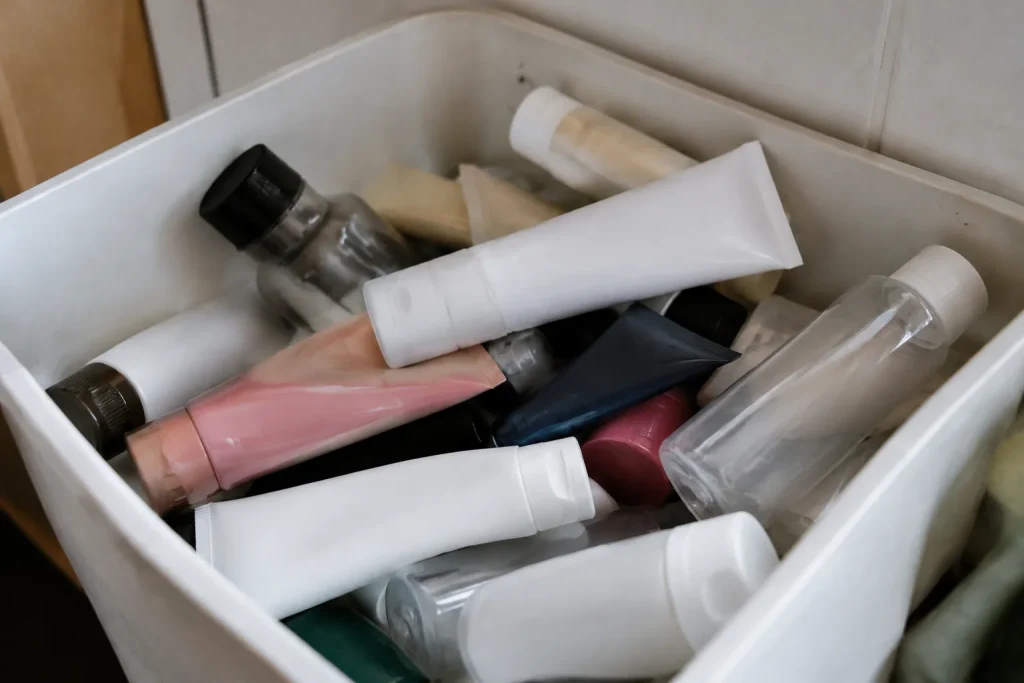 Tubes de creme et flacons vides dans un bac